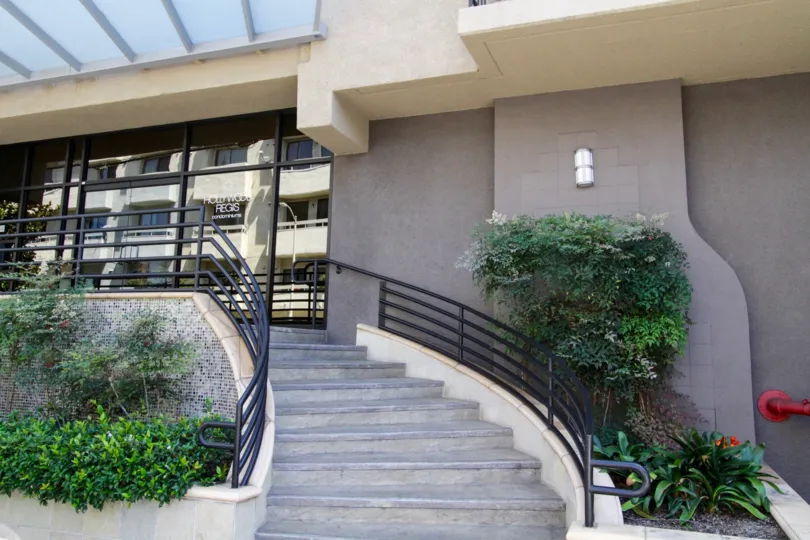Concrete stairs wrap around to the Hollywood Regis front entrance