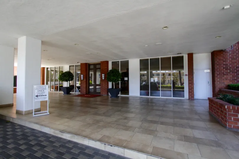 A covered entry plaza to Hollywood Versailles Tower with a porte cochere