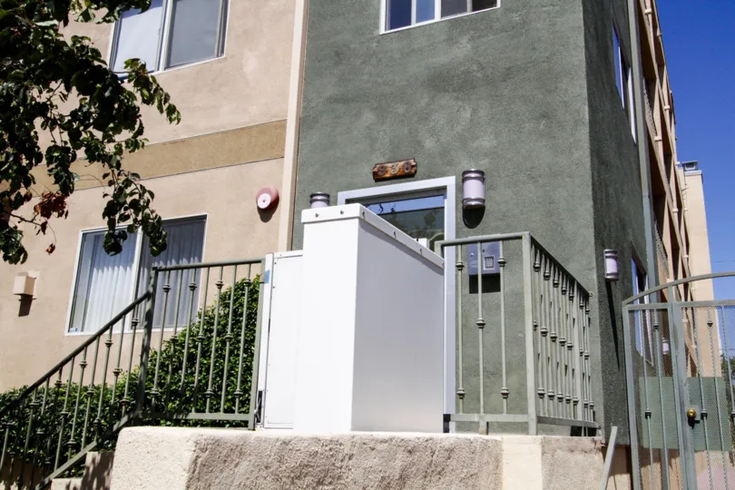 A wheelchair elevator is at the front of the Hudson Villas Building entry