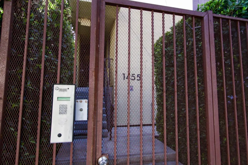 A rusted metal gate leads to the entrance of Sunset Blvd Lofts at Bronson