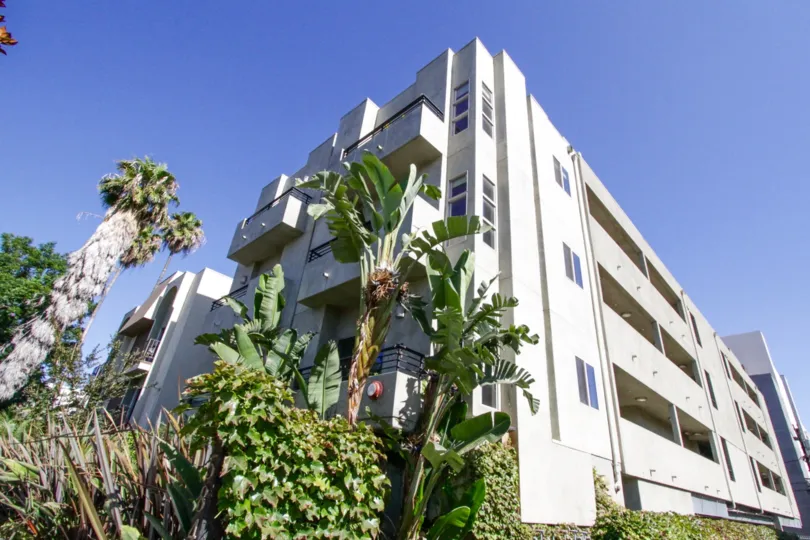 The Mark is a smooth grey concrete building with balconies extended off the front and recessed on the sides