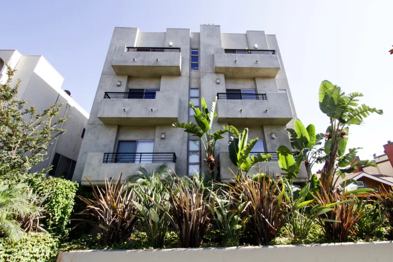 A large raised planter filled with tropical plants greets residents at the front of The Mark