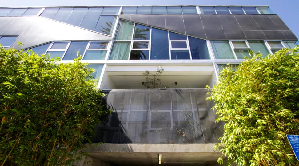 A tall balcony area off one unit covered by metal sheeting adding privacy yet letting in light
