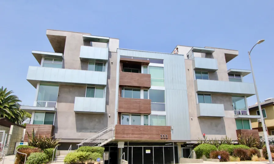 Front view of 333 Wilton in Koreatown, California from the sidewalk and showing the 3 stories of the building and balconies