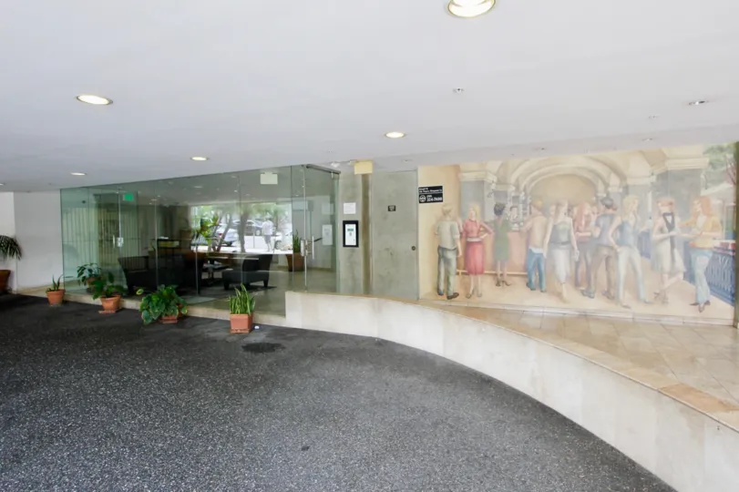 The quaint entrance to the Barcelona Tower, with verdant plants and a mural