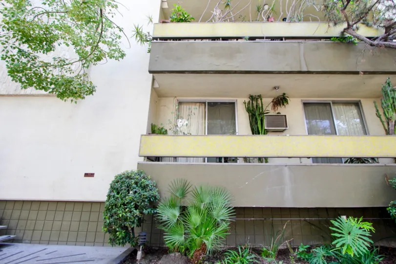Side of building at Essex House with personal terraces, landscaping and air conditioning units.