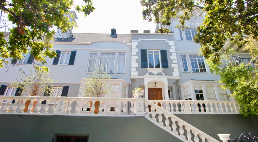 An exterior flight of stairs and entrances to French Chateau in Koreatown on a sunny day