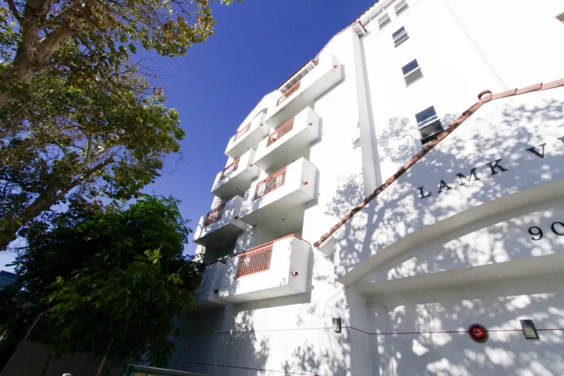 The exterior of the Lamk Villa building is finished with white stucco and a red tile roof