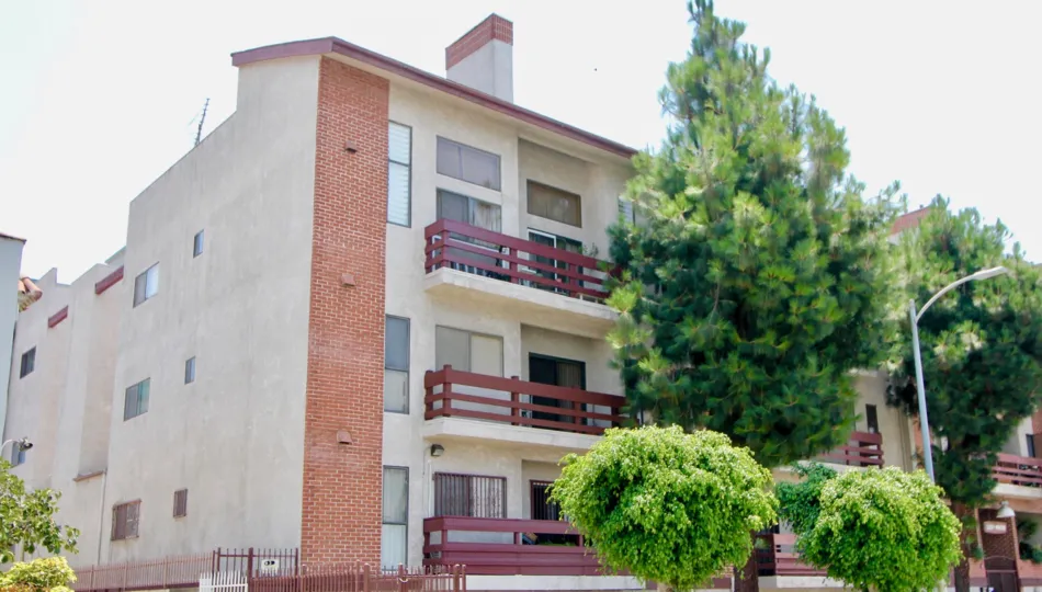 Yellow, red walls of Lucky Mansion along side it's green trees, Koreatown, California