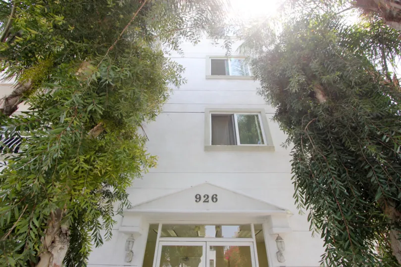 A cloudy day in the Manhattan Villa with a white painted building and glass door.