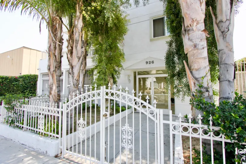 The entrance to building #926 complete with palm trees and a white wrought iron gate in the Manhattan Villa community of Koreatown, California.
