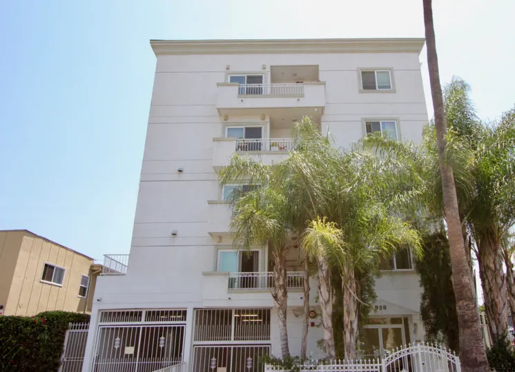 Front of building at Manhattan Villa with large palm trees and personal terraces.