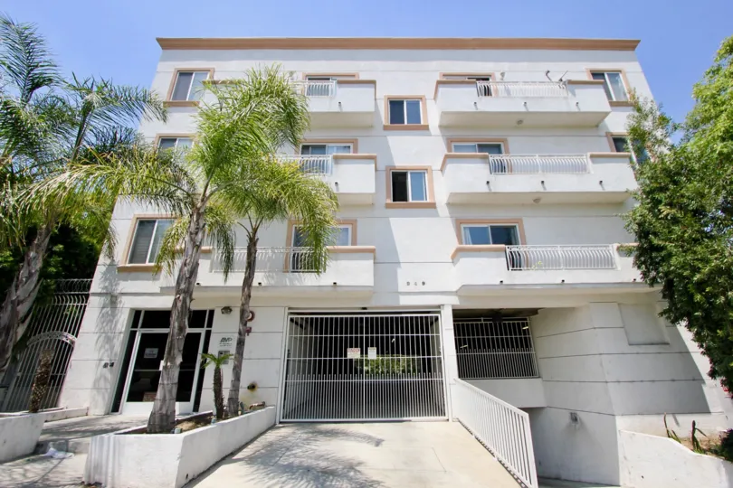 Palm trees and sun in front of a building in Manhattan Village in Koreatown, California