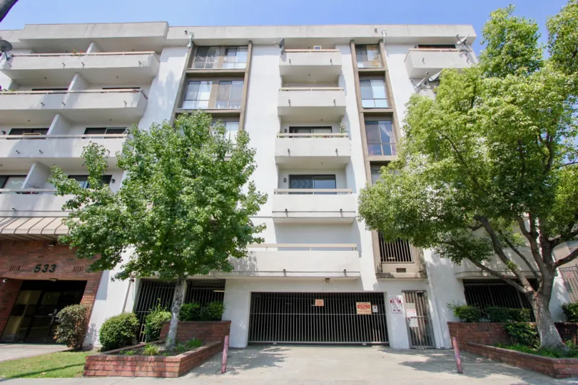 Apartment building in St Andrews Courtyard with personal decks, parking garage, and trees