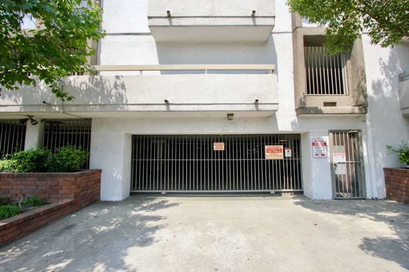 View of closed gated garage entrance of St. Andrews Courtyard with driveway and gated pedestrian door as well.