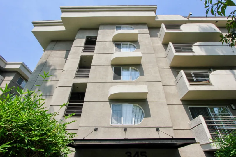 Four stories of balconies, windows, and a modern design of The Cleo in koreatown California.