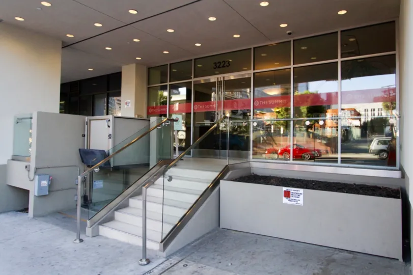Stairs lead to the glass wall entry of The Summit on Sixth