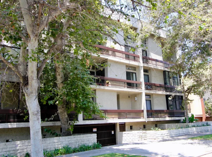 Side of building at The Terrace with personal porches with sliding doors and trees