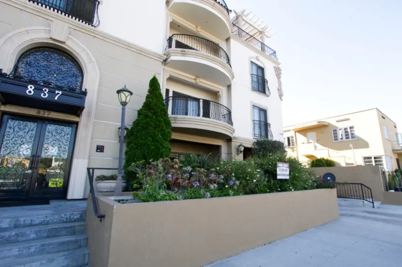 Raised planters separate the street from the front entry of Wilshire Park Villa