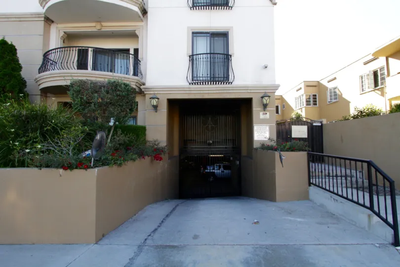 A gate provides privacy to the subterranean parking area for Wilshire Park Villa