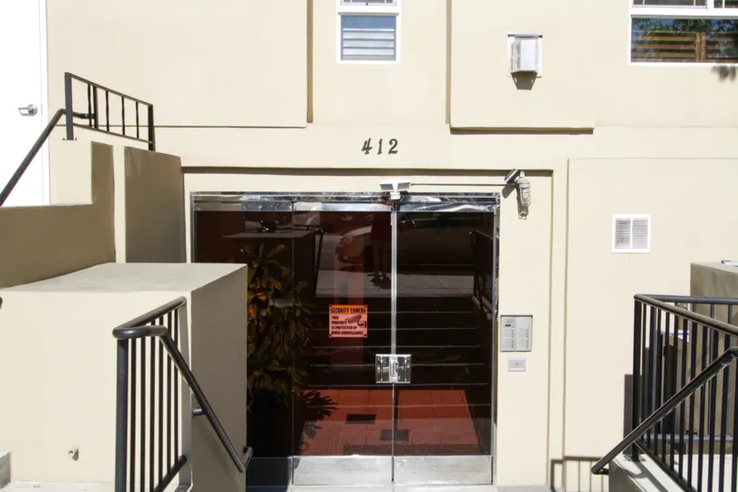Down a flight of stairs are the glass entry doors to Wilton Villas