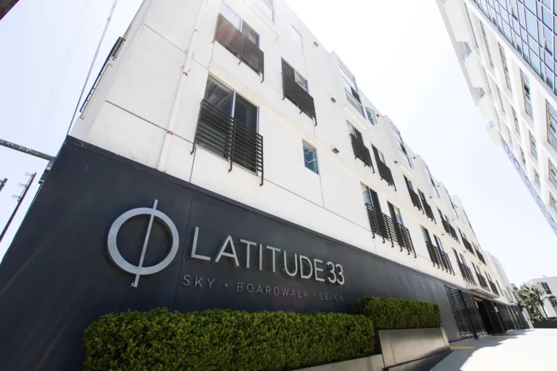 The sign of Latitude 33 Boardwalk Collection on the building