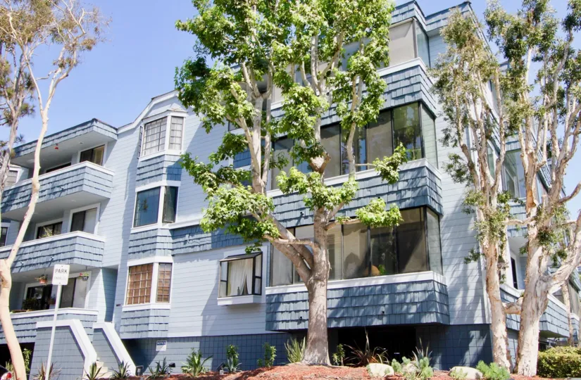 A lovely day at Via Marina Tahiti, a residential blue building with the feel of community living with lovely trees.
