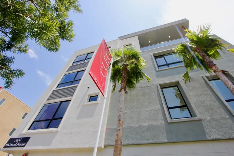 View of Cleo apartment building from the street, showing a Cleo flag, in Playa Vista, CA