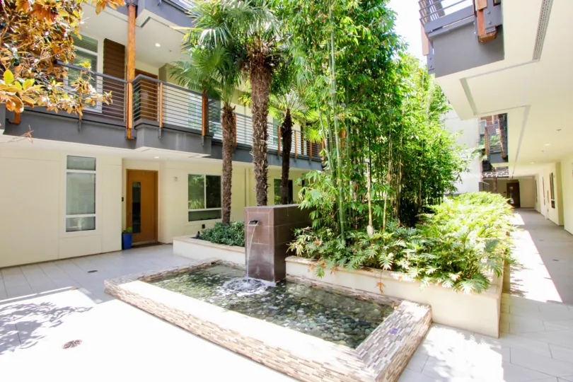 A building in the Primera Terra neighborhood with multiple balconies and palm trees in the courtyard