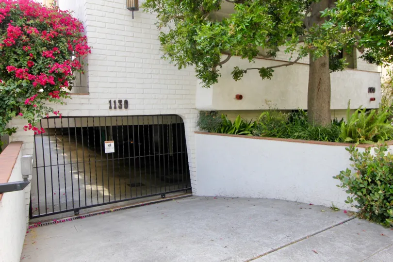 A gateway for a house parking in santa monica - california with trees covered to the underground parking