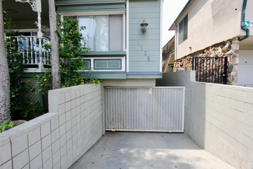 Gated parking entrance to 1138 12th St with white brick on either side.