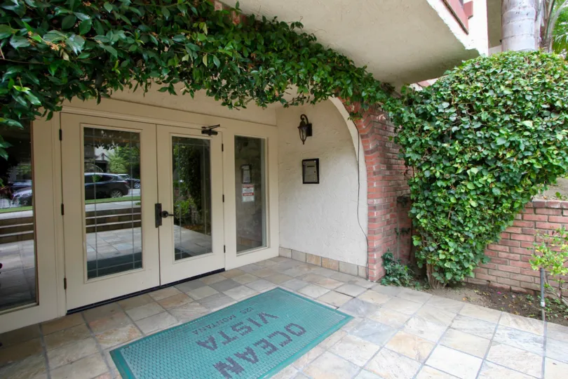 Entry of a big building with white gates and plants in santa monica