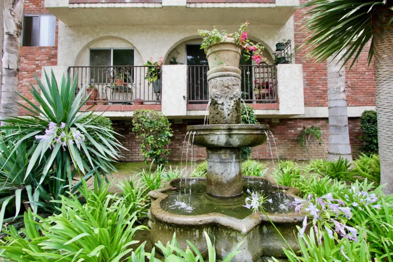 A fountain in front of balconies surounded by bricks at 125 Montana Ave in Santa Moinca