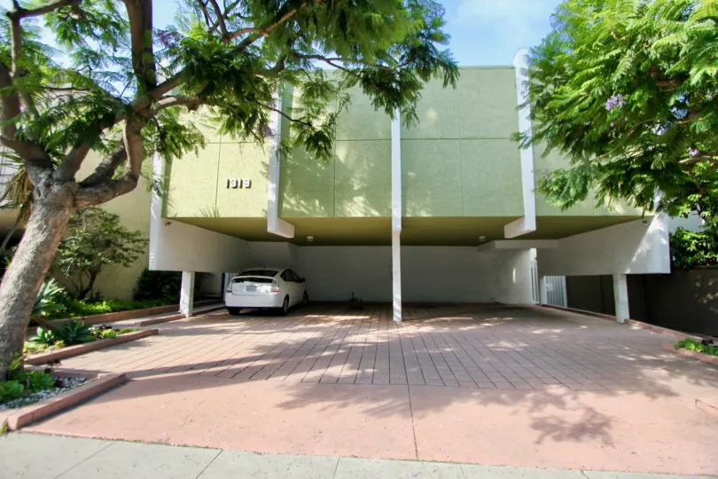Parking spaces of 1319 11th State with trees on either side on a sunny day.