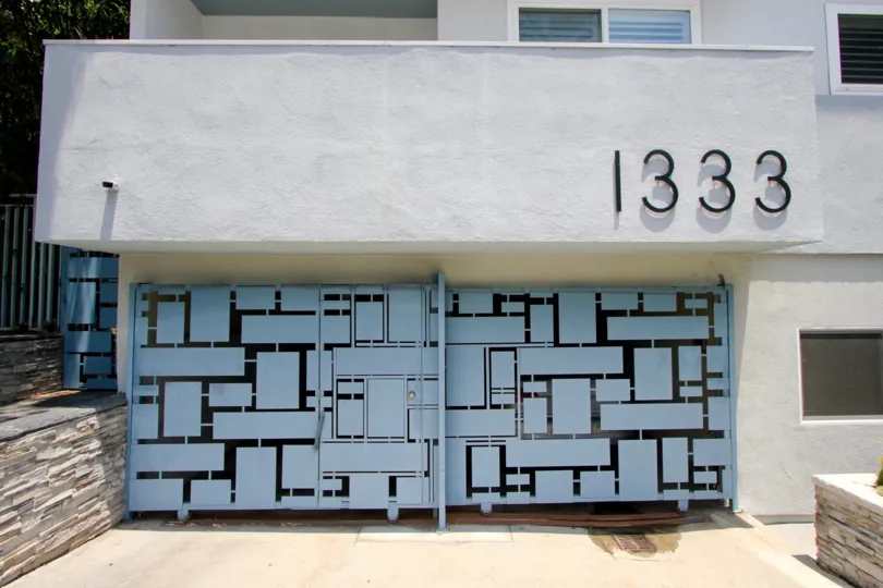 THE GATE WITH SKY BLUE AND BLACK COLOUR AND IT CLOSED THE FIRST FLOOR WITH WINDOWS AT THE MORNING TIME
