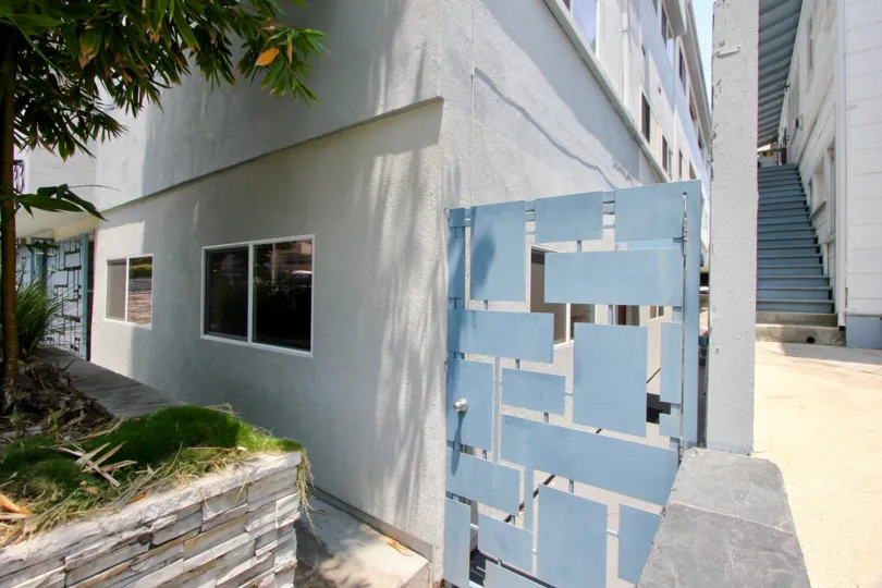 A side entrance in 1333 14th St. community with fancy blue block steel gate.