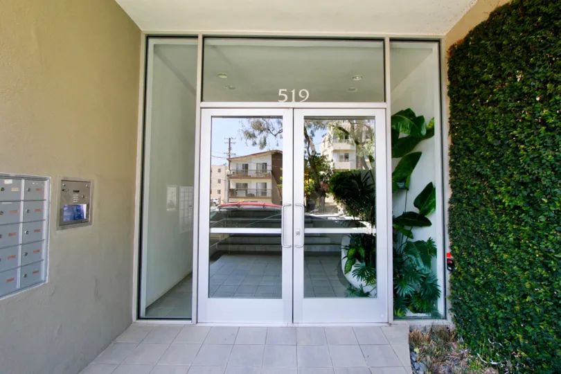 Entrance doors with mailboxes to the left and brush to the right of 519 California, Santa Monica, California