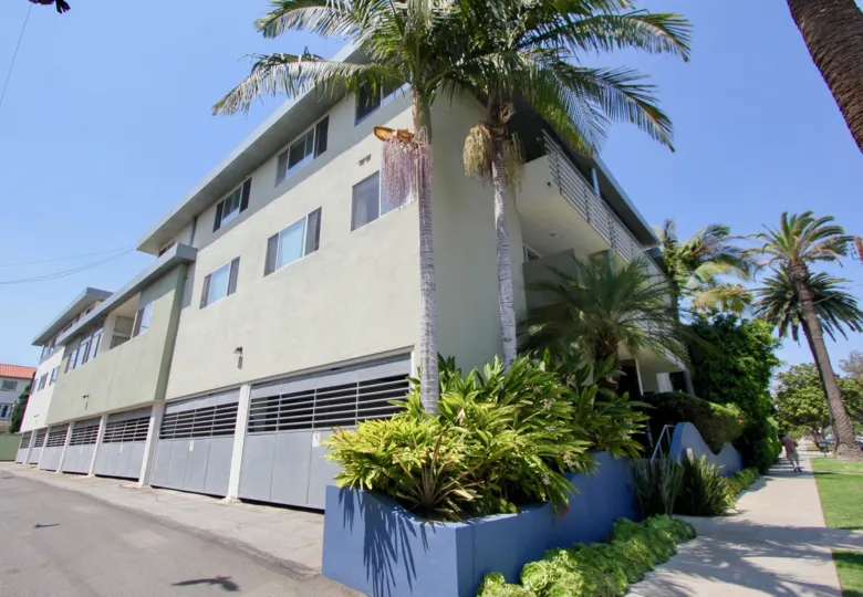 A grey building in the 519 California community with large blue garage doors