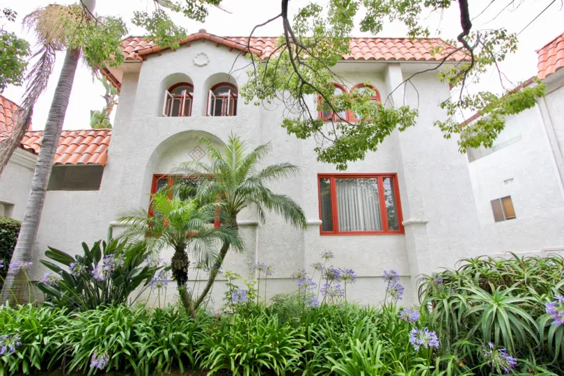 In a sunny morning the house is looking so beautiful and around green leafy trees and plants flowers