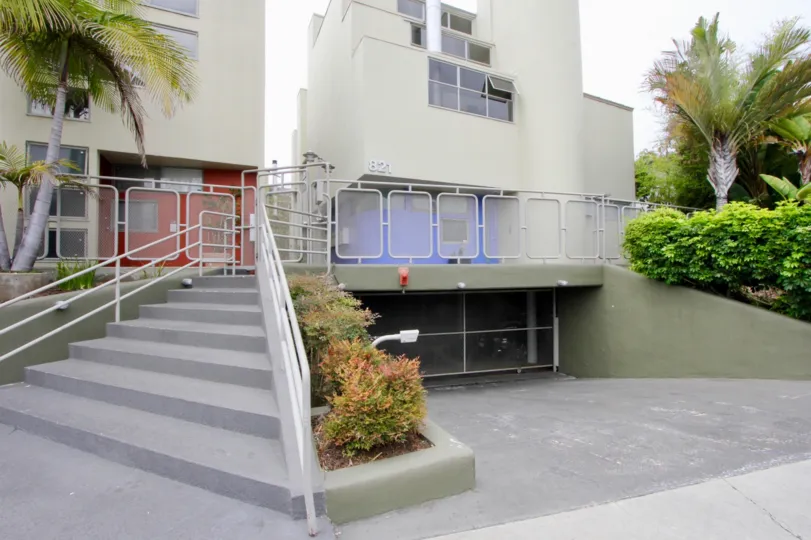 Building surrounded with lush green bushes and trees and a parking in the basement at 821 Bay St in Santa Monica in California