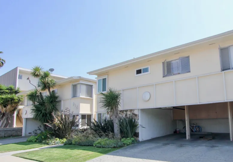 A big house in California with a long lawn and parking area