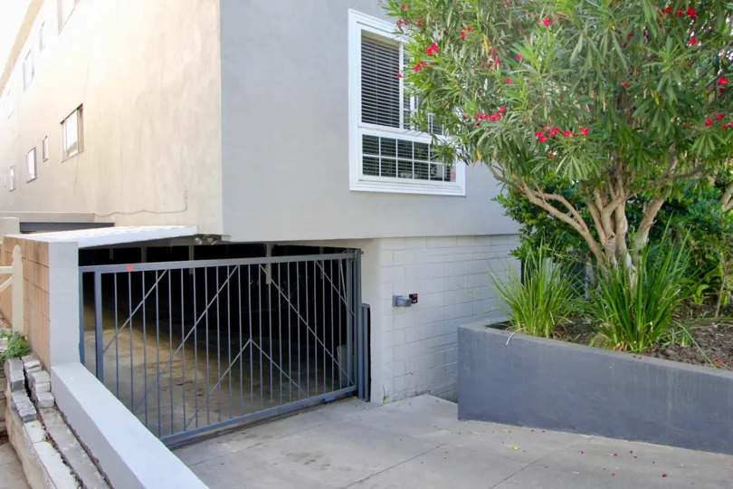 Parking garage entrance of 994 11th St with trees and bushes to the right.