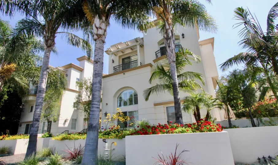 A semi-traditional housing rows in Berkeley Manor community with palm trees.