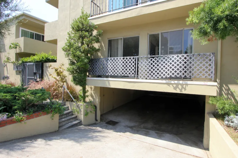 A yellow house in the Berkeley Street community with white railings and a single garage