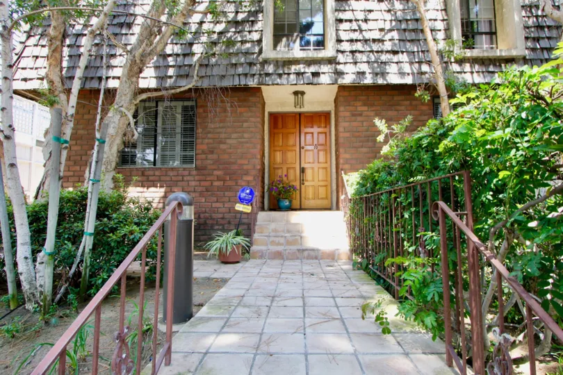Wooden door to Chateau Regency with a stone sidewalk leading up to it.
