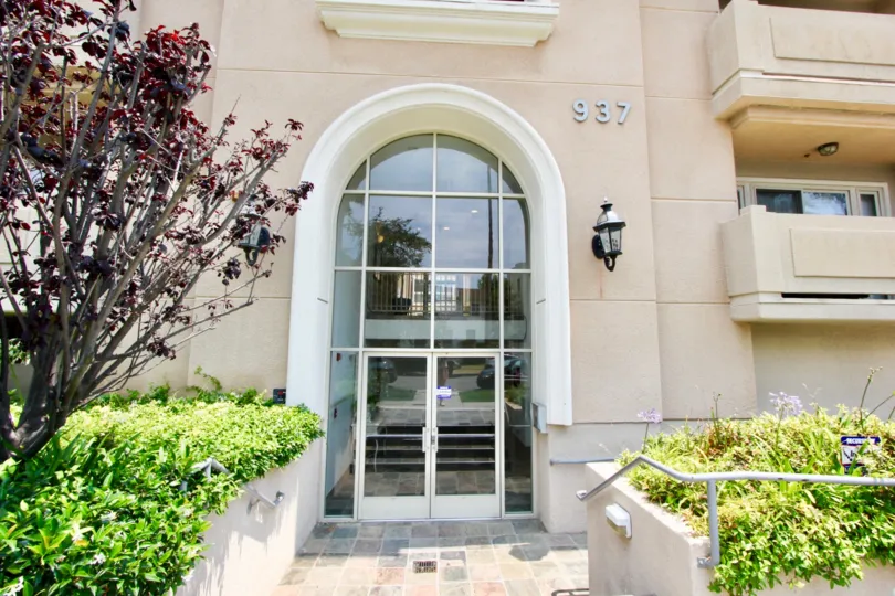 THE DOOR WITH CLOSED GLASS AND WITH A NUMBER WITH BALCONY AND SOME PLANTS ALSO AVAILABLE IN THE MORNING TIME.