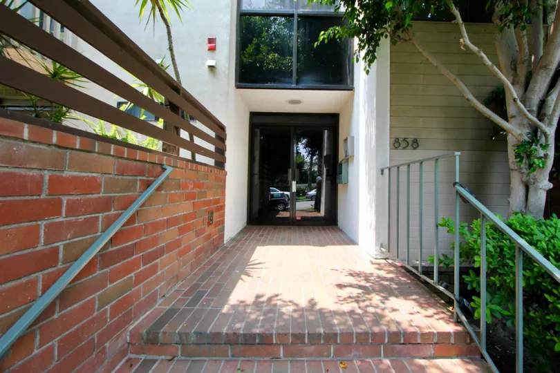 The roof is flat and is covered with red roof tiles. Two large chimneys sit at the side of the house. A few large windows let in just enough light to the rooms below the roof. The house itself is surrounded by a well kept garden. Grass, flower patches and
