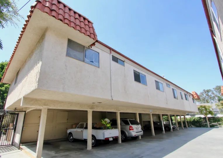 A clear day in the Kansas Ave Condominiums with car parking area.