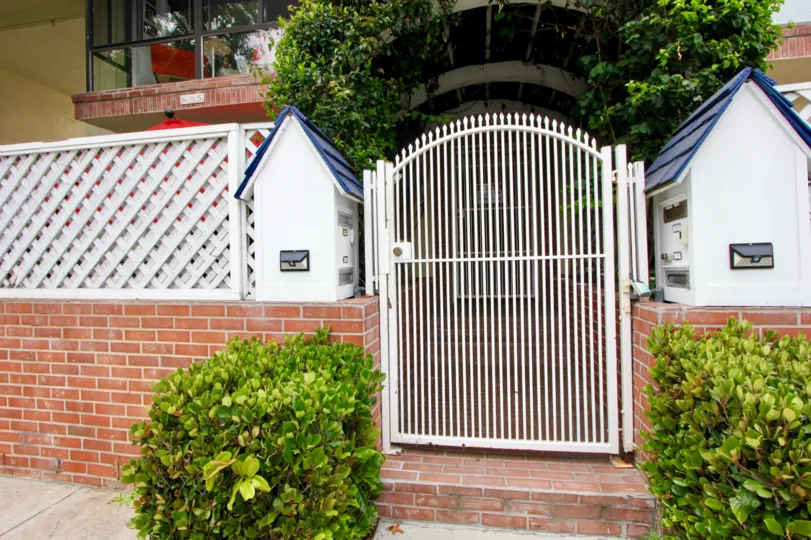 THE WALL WITH GATE AND INSIDE A HOUSE ALSO AVAILABLE WITH GREEN PLANTS ROOF NEAR TO THE DOOR AT MORNING TIME