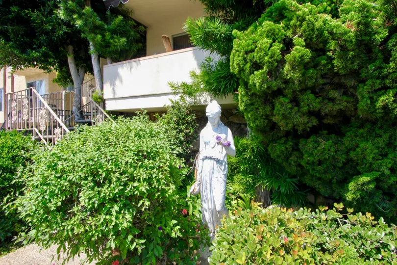 A clear day in the Regency with a sculpture and trees.
